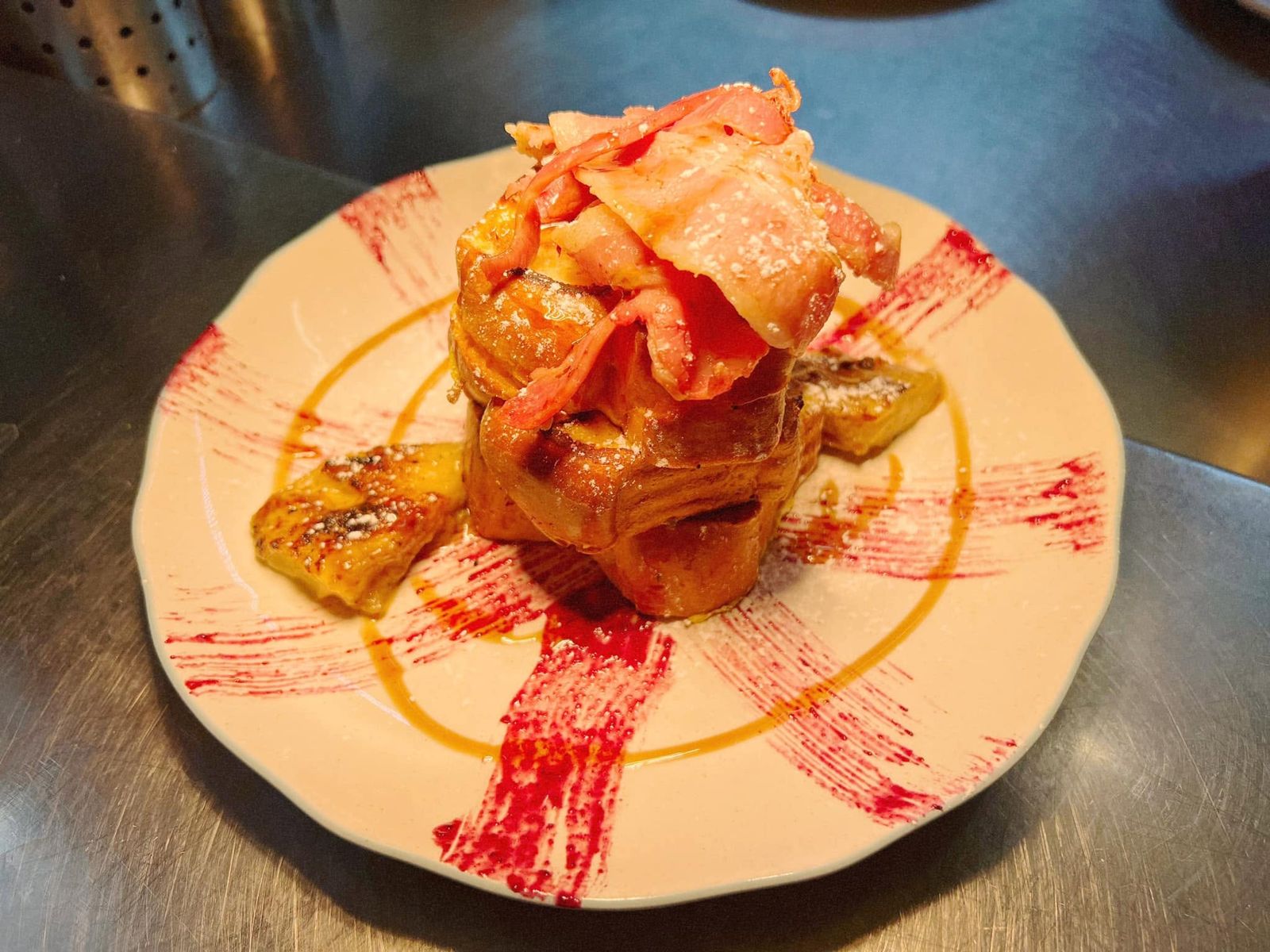 Torre de tostadas francesas con panceta, ananá caramelizado, azúcar impalpable y coulis de frutos rojos